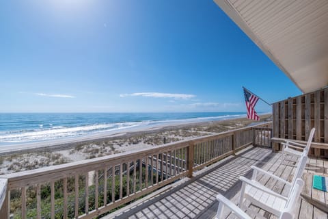 Stunning oceanfront deck with direct beach access and sweeping coastal views under endless blue skies.
