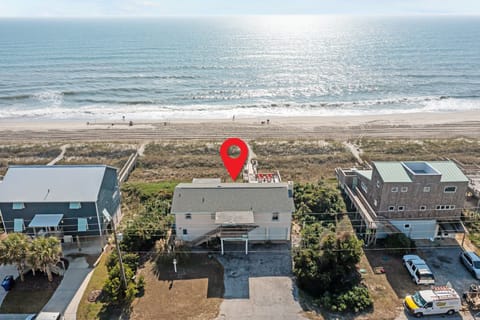 Beachfront vacation rental perfectly positioned between ocean waves and coastal homes, offering direct beach access.
