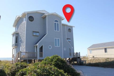 Distinctive multi-story beach house with unique architecture situated in coastal neighborhood near the shore.