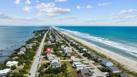 Stunning aerial view of beachfront community with pristine sandy shores and coastal homes surrounded by natural landscapes.