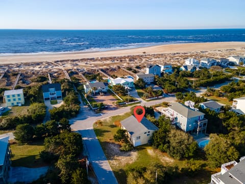 Aerial view of beachfront property location with pristine sandy shores and coastal neighborhood setting just steps from the ocean.
