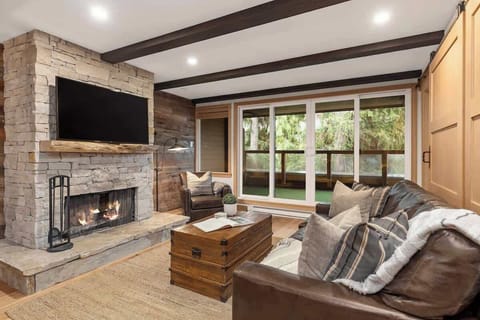 - Gather by the fire in a cozy Whistler-style living room  
- Leather seating and nature views enhance the calm  
- Perfect place to unwind after outdoor adventures  