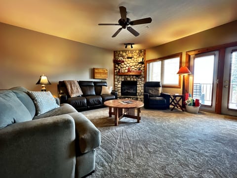 Spacious living room with gas fire place with door to deck and hot tub