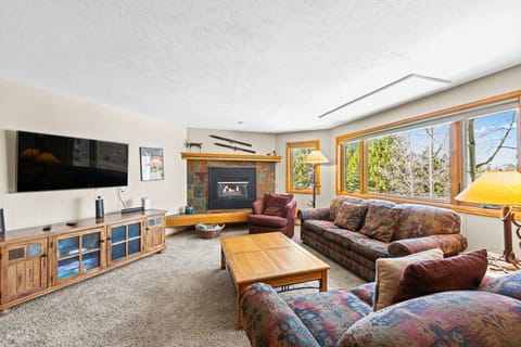 Unwind in your spacious living room featuring a cozy fireplace, large TV, and comfortable seating where you can relax after mountain adventures.