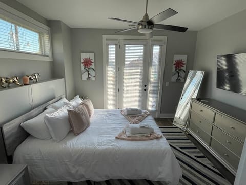 Bedroom Retreat: Bright and airy room with plush bedding, stylish decor, and access to a private patio!