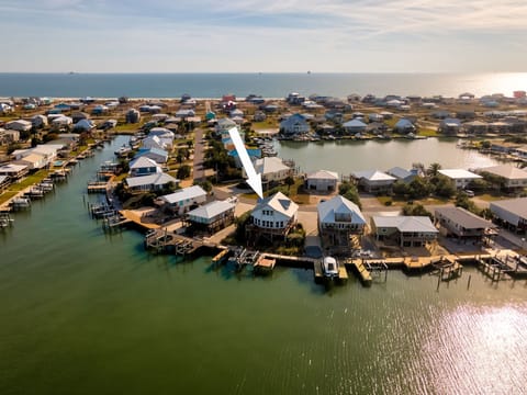 Aerial view showcases this waterfront property among canal homes, with beach access and boat docks in a coastal community.