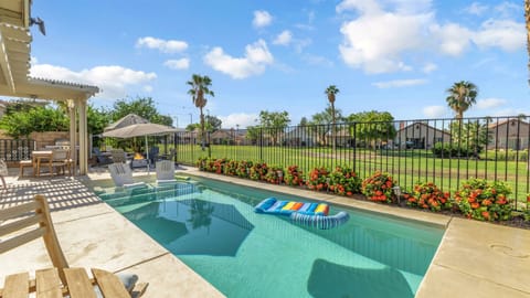 🏖️ Relaxation Meets Style Beautifully landscaped pool area with vibrant flowers and comfortable seating, designed for relaxation and outdoor fun.
