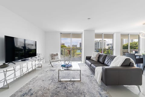 Spacious modern living room with Smart TV, dining area, and balcony at Bay Harbor Islands vacation rental near Miami Beach and Bal Harbor Shops