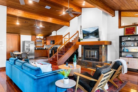 Choose your spot in our open-concept retreat, complete with a well-equipped kitchen, versatile seating, and a charming wooden staircase beckoning to the upper level.