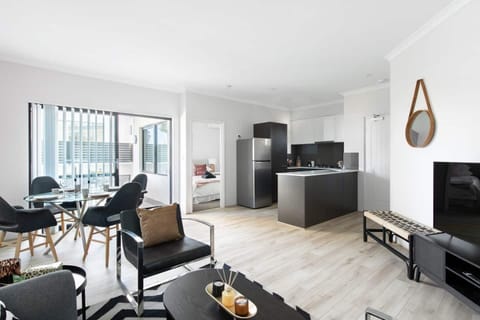 Open-plan space with a cozy living area, modern kitchen, and a bright dining nook. 