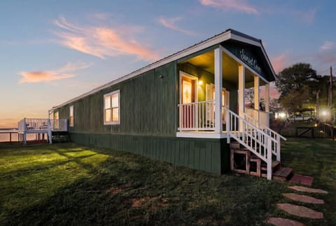 Lakefront cabin exterior with porch at sunset
