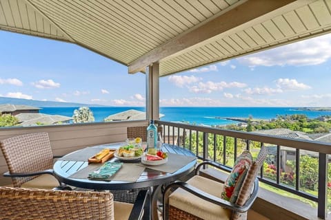 Ocean-view wraparound lanai with four-seat dining set and cushioned chairs, ideal for sunset meals overlooking Kapalua's lush coastline.