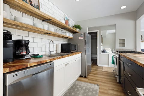 Long galley kitchen w/ generous counter space & stainless appliances for easy meal prep.
