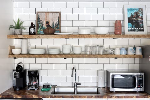 Open shelving & subway tile backsplash add charm to this well-equipped kitchen corner.