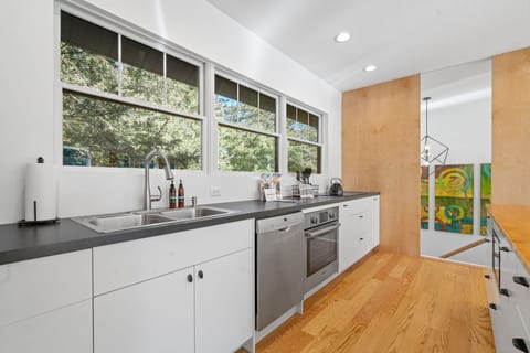 Cook your favorite meals in this bright, modern kitchen with sleek appliances and garden views through large windows.