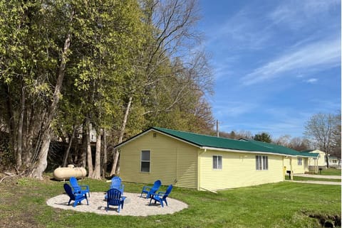 Private firepit with adirondack chairs to the side of the cabin.