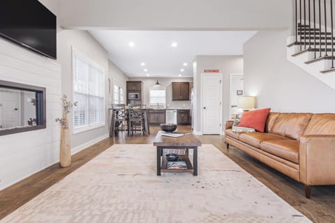 Bright open living with fireplace, bar seating, and modern kitchen