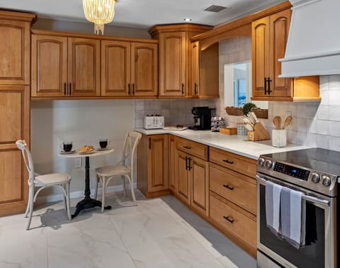 This kitchen features warm wood cabinetry, sleek quartz countertops, and stainless-steel appliances for a perfect blend of style and function.