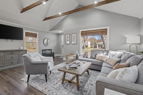 Bright and spacious living room with vaulted ceilings, exposed beams, and comfortable seating—perfect for relaxing after exploring Kansas City.