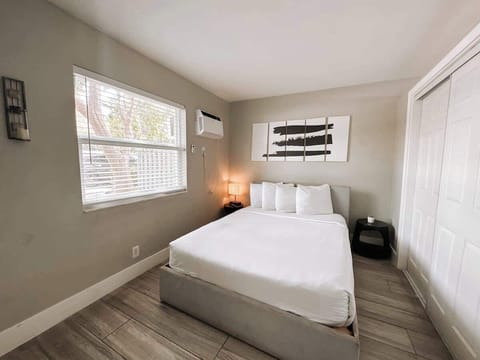 Bedroom with upholstered bed, bright windows and ample closet storage.