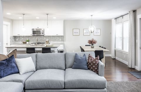 The main floor living room with a 65-inch tv with an open floor plan to kitchen