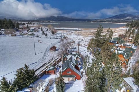 Aerial winter view showcasing the cabin set near a snowy landscape and frozen lake.