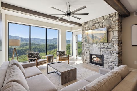Spacious and Scenic Living Room with Stone Fireplace, Floor to Ceiling Windows with Smoky Mountain View, Smart TV's and WiFi throughout vacation condo