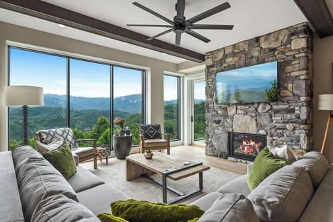 Spacious and Scenic Living Room with Stone Fireplace, Floor to Ceiling Windows with Smoky Mountain View, Smart TV's and WiFi throughout vacation condo