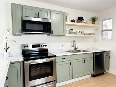 The kitchen is fully equipped with an oven, microwave, dishwasher, and full sized refrigerator with an ice maker. 
