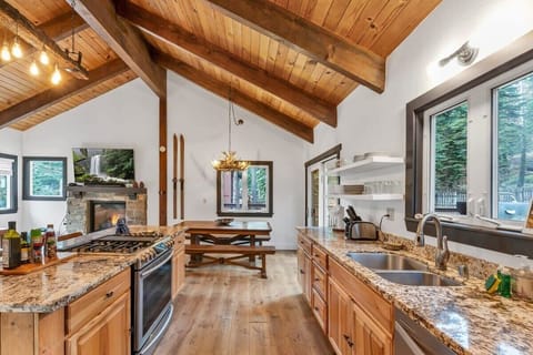 The kitchen is outfitted with a full range of appliances including a modern Samsung Smart oven and gas stovetop, ample counter and cabinet space, and a kitchen bar with seating for 3.