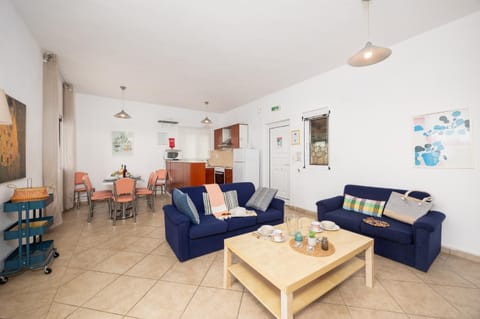 Open-plan living room with sofas, dining area, ornamental fireplace, WiFi internet, and satellite TV