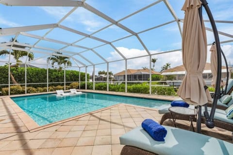 Private screened pool with loungers, perfect for relaxing in the sun.