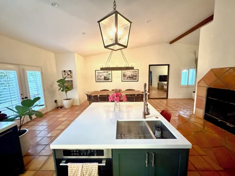 Spacious Kitchen Island with Fireplace and Double French Doors leading Outside.