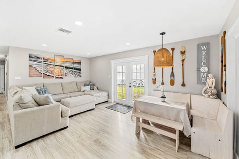 Bright & spacious living room with comfy couch and access to the backyard .