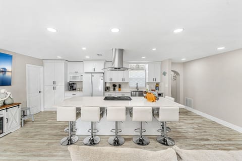 Kitchen with sleek countertops and stools, perfect for casual dining or quick meals.