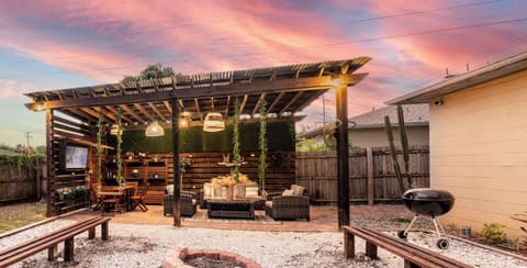 Outdoor living space equipped with Smart TV, Outdoor Grill, Smoker, dining area, appropriate lighting and fans