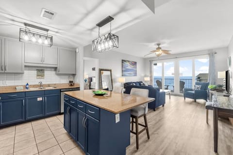 View of fully stocked kitchen, living room with pull out sofa flat screen TV and stunning ocean views