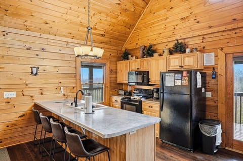 Your rustic cabin kitchen features warm wood throughout, complete with modern appliances and an island perfect for gathering with loved ones.