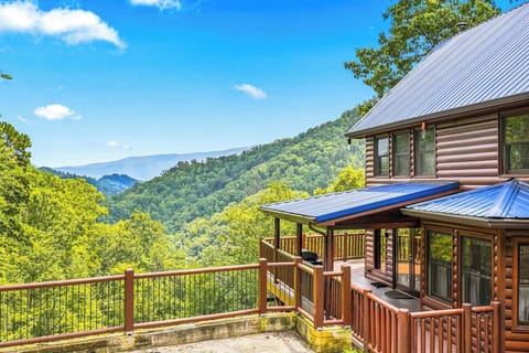 Your private mountain retreat features a spacious deck where you can soak in sweeping views of lush, rolling peaks under open skies.