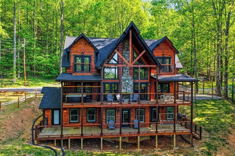 Stunning log cabin retreat nestled among towering trees, featuring expansive decks and rustic charm in a peaceful forest setting.