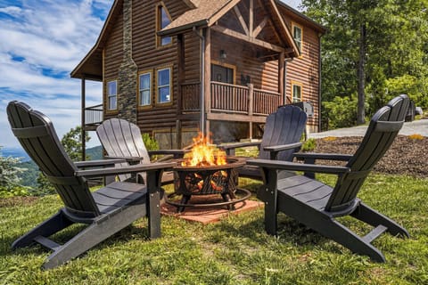 Charming log cabin retreat nestled among lush trees, with a crackling fire pit surrounded by cozy Adirondack chairs inviting you to relax and enjoy the peaceful mountain setting.