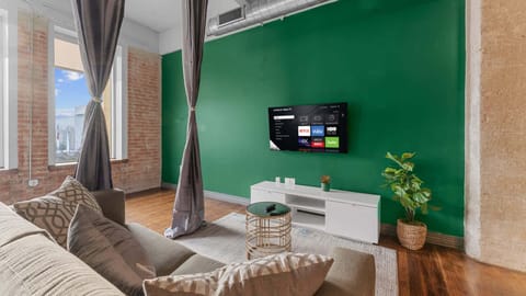 Living Room Oasis: Vibrant green accent wall and sleek decor for relaxation and entertainment!