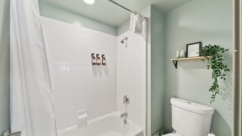 Bathroom with toilet, shampoo, conditioner and shower gel.