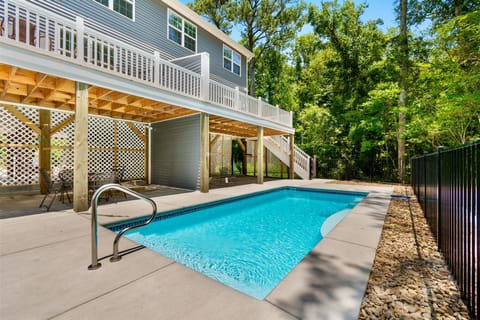 Your shared pool awaits beneath the covered deck—perfect for cooling off after sunny adventures, with shaded seating nearby.