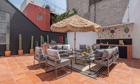 Área de estar con asador en patio trasero. | Living area with barbecue in the backyard.