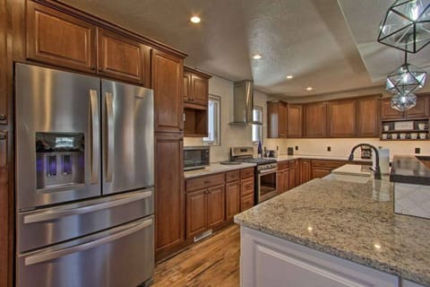 Chef’s kitchen with stainless steel appliances, granite counters, and a large prep island.