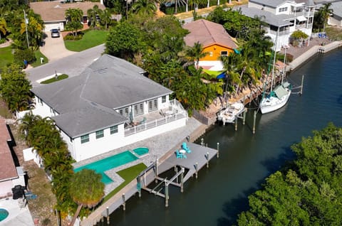 Bird's eye view of the back yard of the home showcasing the large pool and spa with boat and canal access