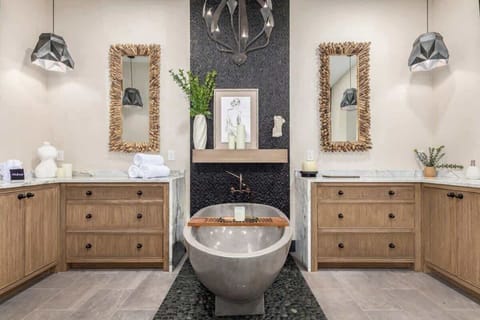 Custom Primary En-suite bathroom with his & hers vanities, natural stone soaking tub