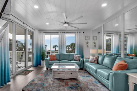 Relax in your bright coastal living room with ocean-breeze colors, comfortable seating, and panoramic views of palm trees and beach.
