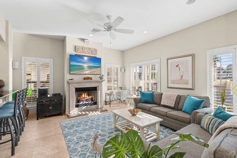 Sink into plush seating by your crackling fireplace, where coastal blues meet warm comfort in this perfectly appointed living space.